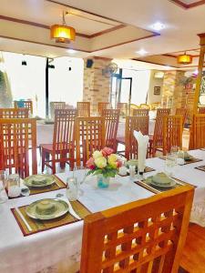 a dining room with a table with flowers on it at Sila Resort Sukhothai in Sukhothai