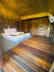 um quarto com uma cama num quarto de madeira em HaiVen Farm Homestay 