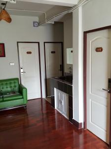 een woonkamer met een groene bank en een spiegel bij Bangkok Check Inn @Chareon Krung in Bangkok