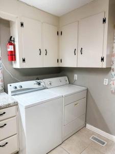 a kitchen with white cabinets and a white dishwasher at Nichol's Nest in Anniston