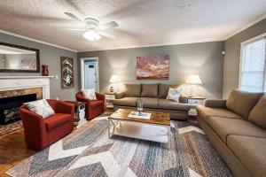 a living room with a couch and chairs and a fireplace at Nichol's Nest in Anniston