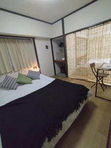 1 dormitorio con 1 cama grande, mesa y ventana en 板橋 RCアネックス Rc201, en Tokio