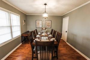 a dining room with a long table and chairs at Nichol's Nest in Anniston