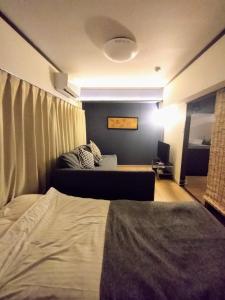 1 dormitorio con 1 cama y 1 sofá en una habitación en 板橋 RCアネックス Rc201, en Tokio