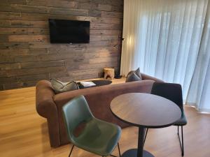 Barossa Weintal Hotel في تانوندا: غرفة معيشة مع أريكة وطاولة