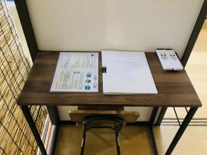 a wooden table with a remote control and papers on it at 板橋 RCアネックス Rc201 in Tokyo