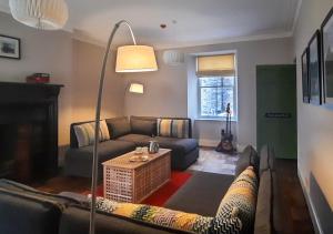 sala de estar con sofá y lámpara de pie en The Manor Criccieth, en Porthmadog