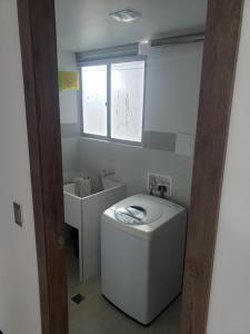 a bathroom with a toilet and a sink and a window at Apartamento amoblado con excelente ubicación en Pasto in Pasto