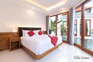 a bedroom with a white bed with red pillows at Villa Mia Seminyak - Boutique Villas in Seminyak