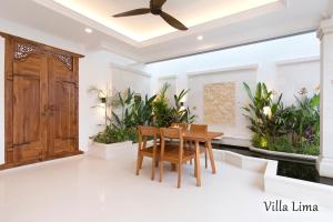 a dining room with a table and some plants at Villa Mia Seminyak - Boutique Villas in Seminyak