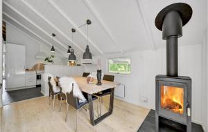 - une cuisine et une salle à manger avec un poêle à bois dans l'établissement Amazing Home In Oksbl With Sauna, à Oksbøl