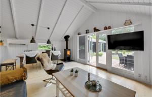 un salon avec une grande télévision et une table dans l'établissement Amazing Home In Oksbl With Sauna, à Oksbøl