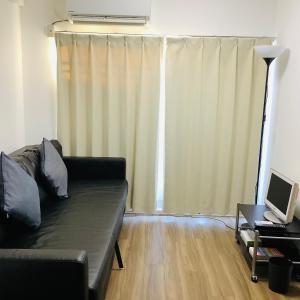a living room with a couch and a laptop on a table at 板橋 RCアネックス Rc202 in Tokyo