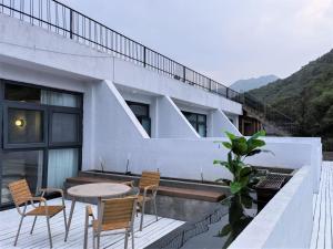 einen Balkon mit einem Tisch und Stühlen auf einem Gebäude in der Unterkunft Delight Inn in Yanqing