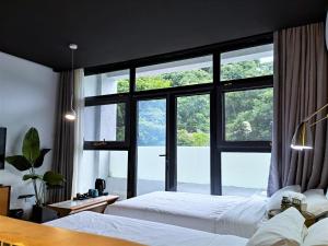 1 dormitorio con 2 camas y ventana grande en Delight Inn, en Yanqing