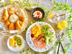 una mesa con platos de comida y pan para el desayuno en COCO TERRACE -Ocean View- en Ito