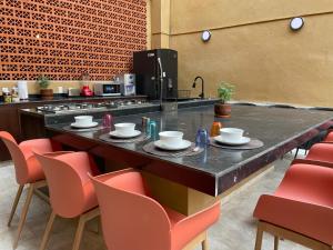 a kitchen with a counter with chairs and a table at Colmena Hotel CDMX Centro in Mexico City