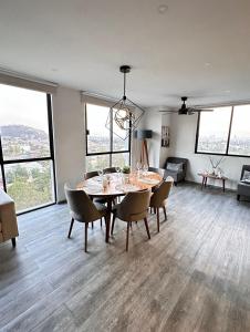 a dining room table and chairs in a room with windows at Entire Luxurious Apartment in Shopping Mall in Mexico City