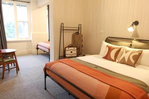 1 dormitorio con 1 cama, 1 silla y 1 mesa en Alpine Hotel, Eat Drink Sleep en Warburton
