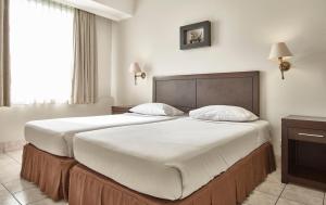 Postel nebo postele na pokoji v ubytování Grand Cikarang Hotel