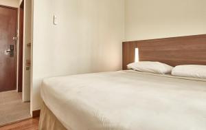 Postel nebo postele na pokoji v ubytování Grand Cikarang Hotel
