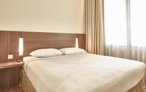 Postel nebo postele na pokoji v ubytování Grand Cikarang Hotel