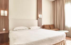 Postel nebo postele na pokoji v ubytování Grand Cikarang Hotel