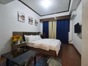 een slaapkamer met een bed en een tafel. bij TemporaryHome -susan in Manilla