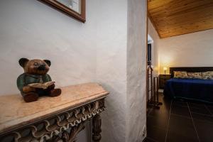 Ein Teddybär, der auf einer Bank sitzt und ein Buch liest. in der Unterkunft Casa Do Forno - Quinta Amoreira in Faro + 45 Fotos