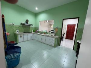 cocina con paredes verdes y puerta roja en Joe’s Homestay Raub Phg, en Raub