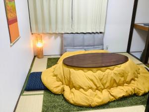 a room with a large yellow bed and a table at 板橋 RCアネックス Rc208 in Tokyo