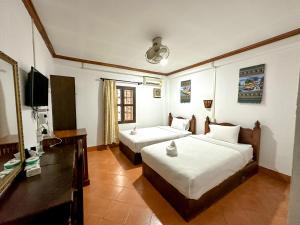 a hotel room with two beds and a television at Chaliya Boutique Garden in Luang Prabang