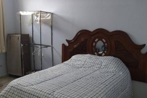 1 dormitorio con 1 cama con cabecero de madera y espejo en Amplia y cómoda casa, para 2 a 8 personas a unos pasos de la plaza, en Ocotlán