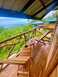 balkon domu ze stołem i ławkami w obiekcie Green Hill Restaurant & Cottages w mieście San Vicente