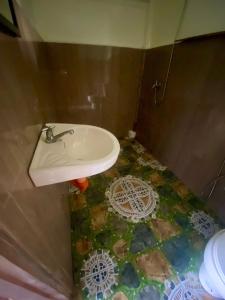 a bathroom with a sink and a mosaic floor at Green Hill Restaurant & Cottages in San Vicente