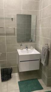 a bathroom with a white sink and a mirror at BALLITO HILLS, 1 bedroom apartment in Ballito