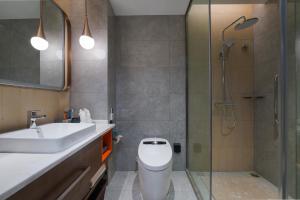 a bathroom with a toilet and a sink and a shower at Home2 Suites By Hilton Wuhan Hankou Railway Station in Wuhan