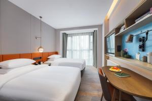 Tempat tidur dalam kamar di Home2 Suites By Hilton Wuhan Hankou Railway Station