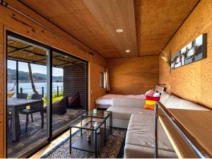 a living room with a couch and a table at Glamping village Seagrand in Matsuura +152 photos
