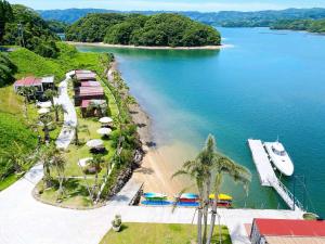 een uitzicht op een strand met een boot in het water bij Glamping village Seagrand in Matsuura