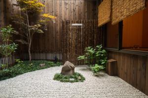 einen Garten mit einem Felsen in der Mitte eines Gebäudes in der Unterkunft Kyomachi Yumeji in Kyoto
