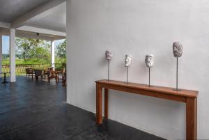 um quarto com uma mesa com máscaras na parede em Ceylon Breeze Sigiriya em Sigiriya