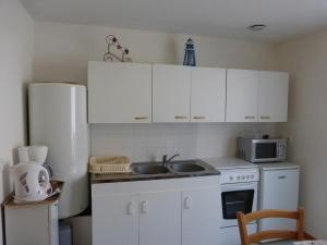 uma cozinha com armários brancos, um lavatório e um frigorífico em Appartement Saint-Hilaire-de-Riez, 2 pièces, 2 personnes - FR-1-224-119 em Saint-Hilaire-de-Riez