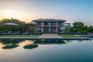 a house sitting on top of a body of water at Ceylon Breeze Sigiriya in Sigiriya