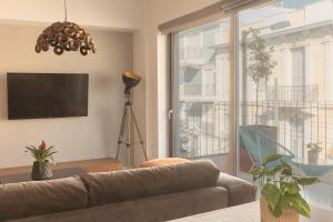 a living room with a couch and a large window at Luxury Apt with Parking-Living Stone Silver in Athens
