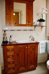 a bathroom with a sink and a mirror at La Rouge Cottage in Bendigo