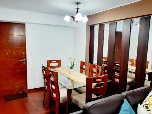 comedor con mesa, sillas y sofá en Hermoso apartamento Unidos En Familia en JESÚS MARÍA, en Lima