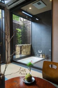 een badkamer met een bad en een groot raam bij Kyomachi Hoshizuki in Kyoto