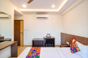 a bedroom with a bed and a kitchen in it at FabHotel Kzar Select in Kolkata