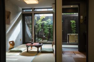 a room with a table and chairs and a window at Kyomachi Hoshizuki in Kyoto